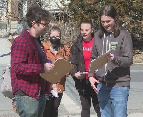 Students canvassing a neighborhood about lead pipe replacement