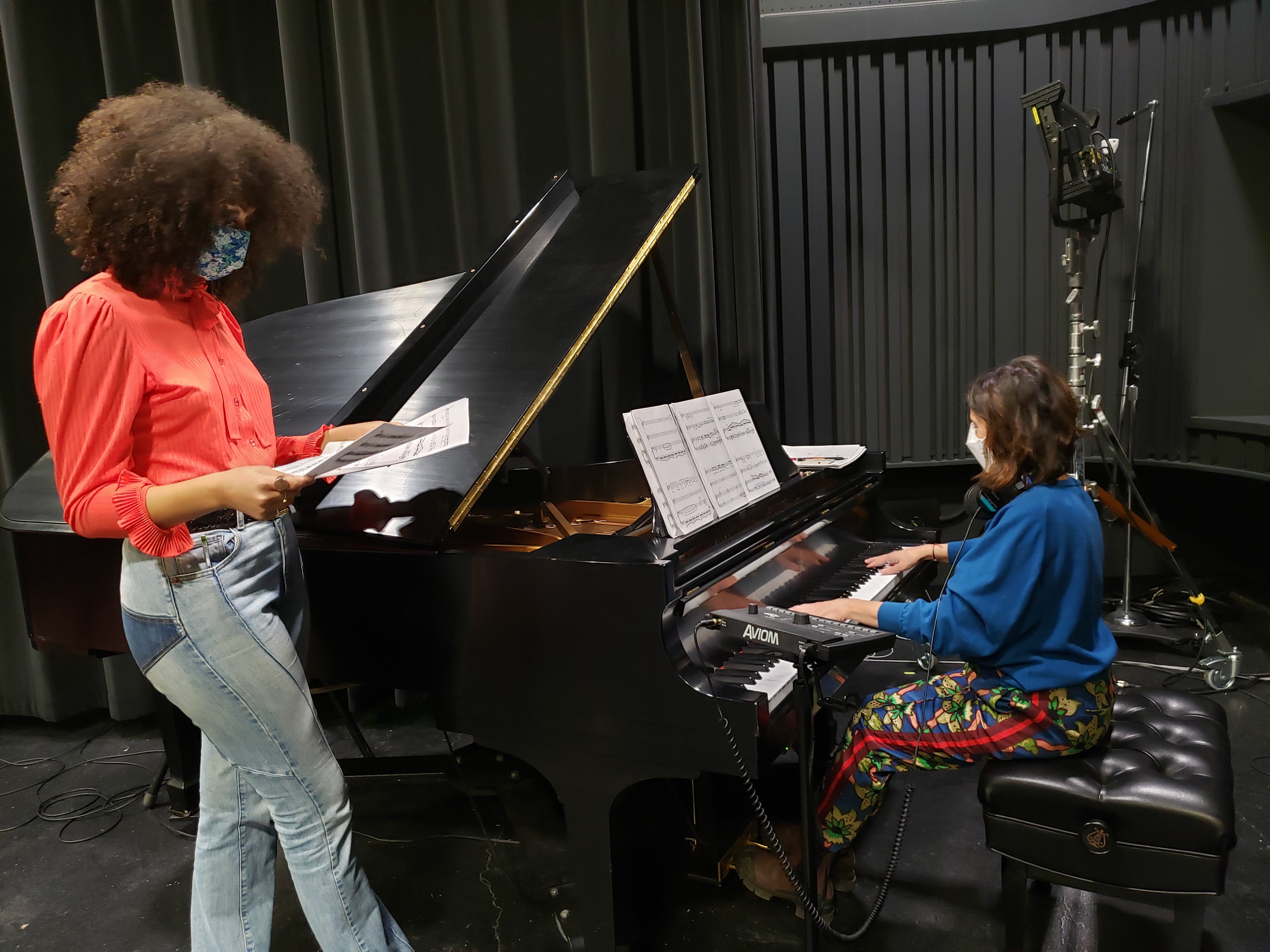 A faculty member and student working at the piano in the recording studio.