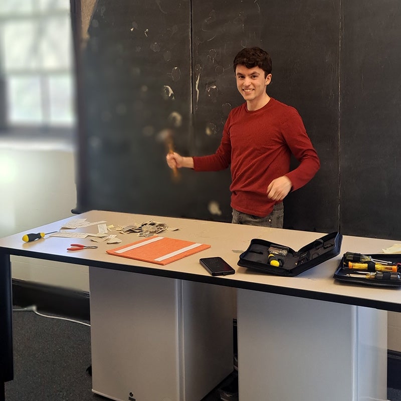 Person working at a lab workstation with tools and materials during a laboratory renovation or equipment installation project.