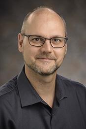 Dr. Pascal Hitzler of Kansas State University, a light skinned, bearded man wearing a black shirt.
